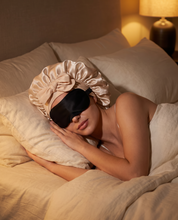 Femme qui dort avec le bonnet de nuit Lunae en satin et un masque de nuit